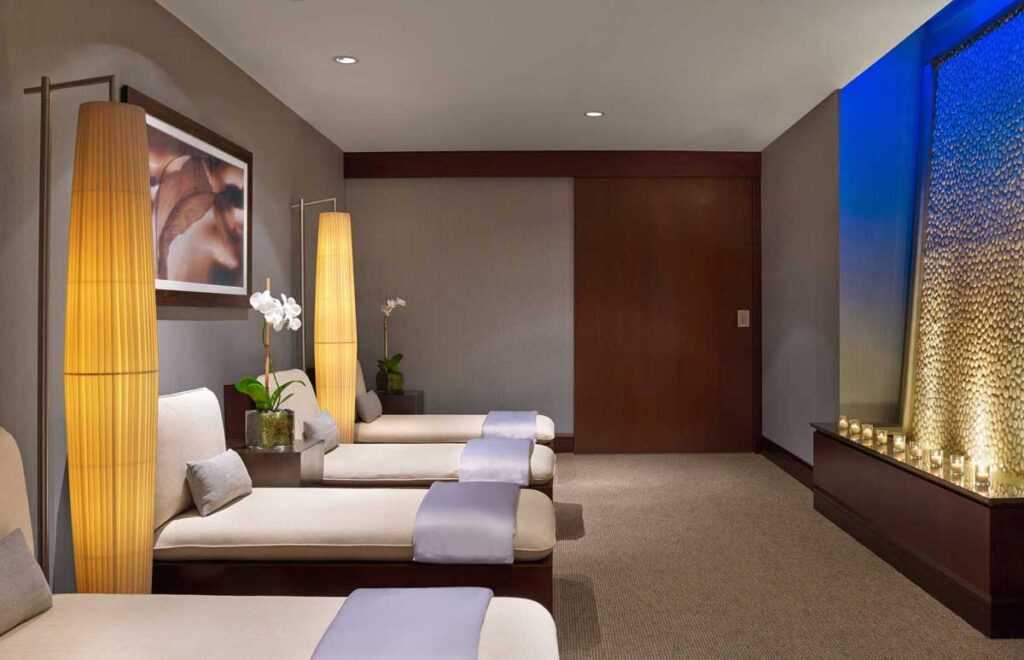 dim room with soft lights around each massage bed