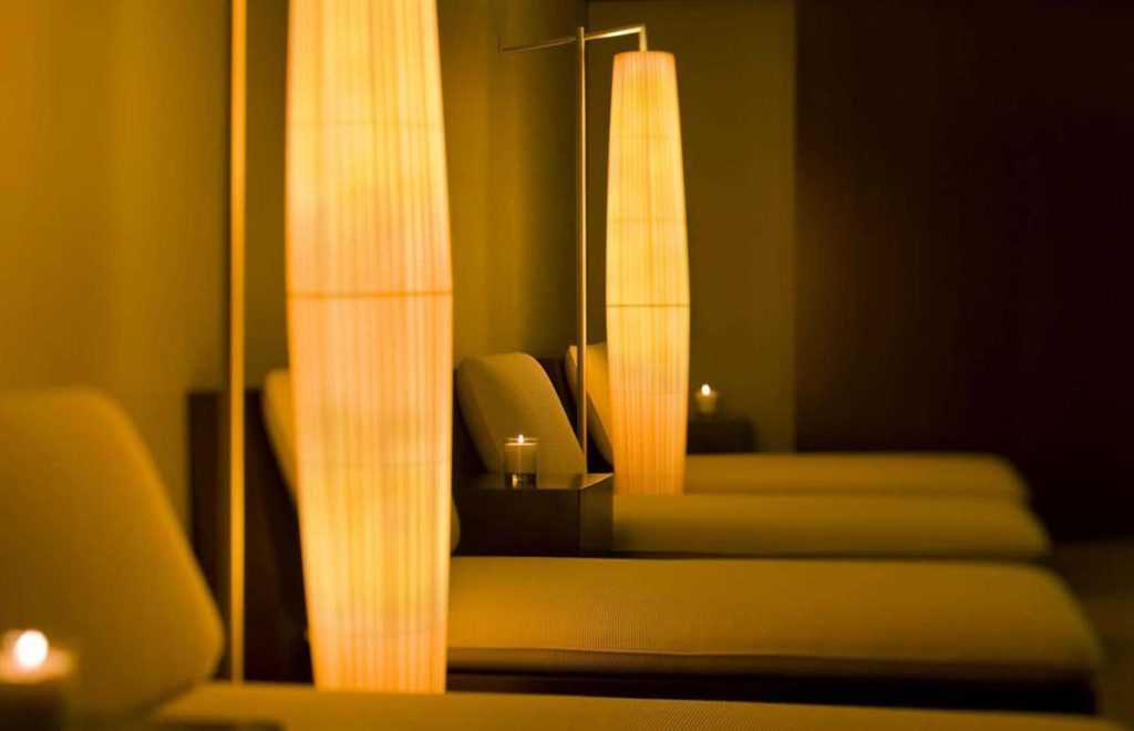 dim room with soft lights around each massage bed