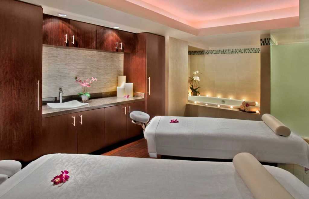 two intimate massage beds in a room with candles lit