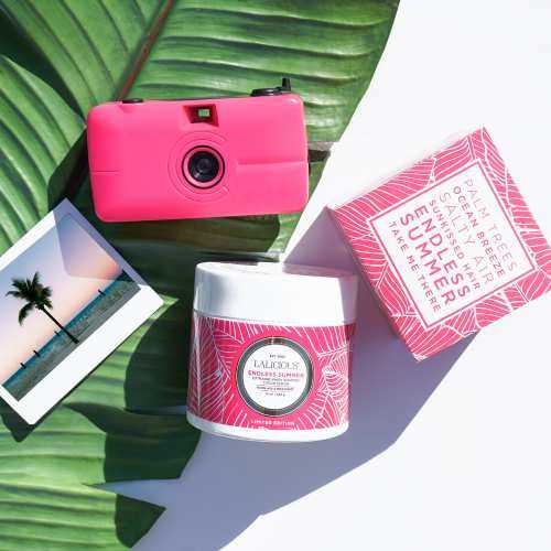 camera and lotions on a palm leaf