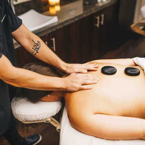 woman being massaged with hot stones on her back