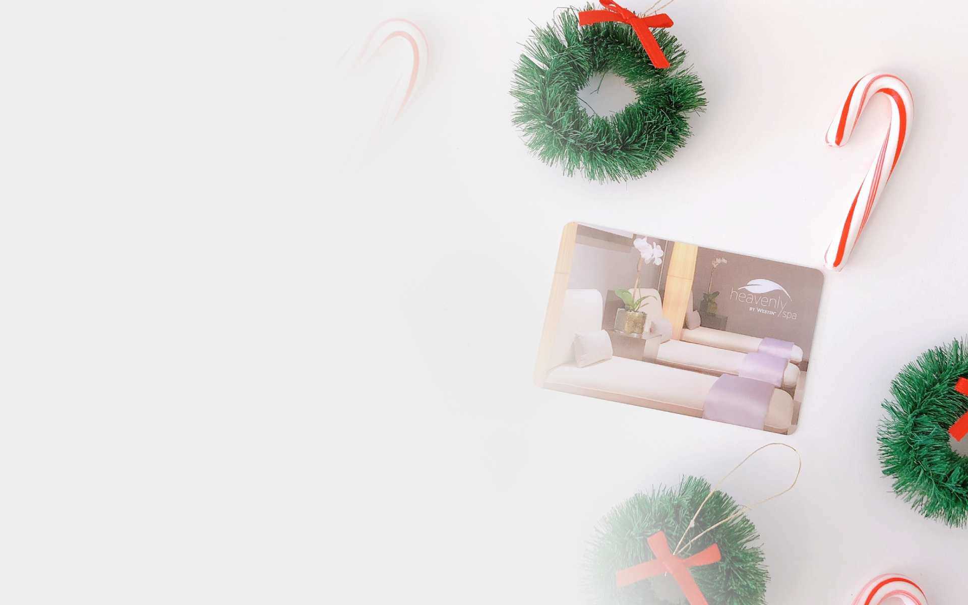 candy canes and christmas wreaths surrounding a gift card
