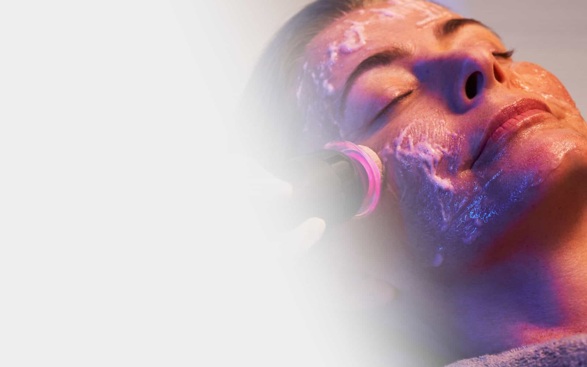 a woman getting a facial mask on her face