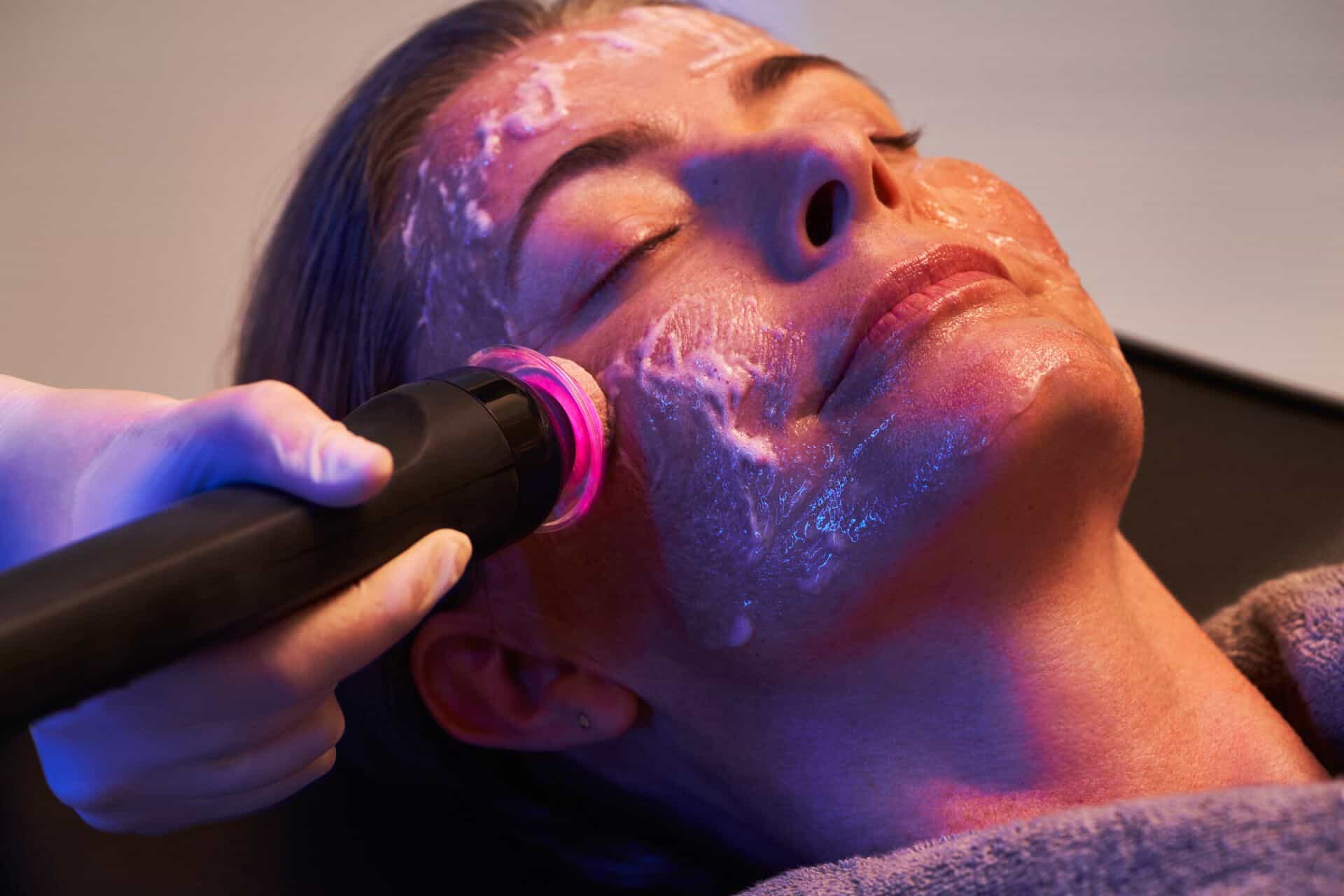 a woman getting a facial mask on her face