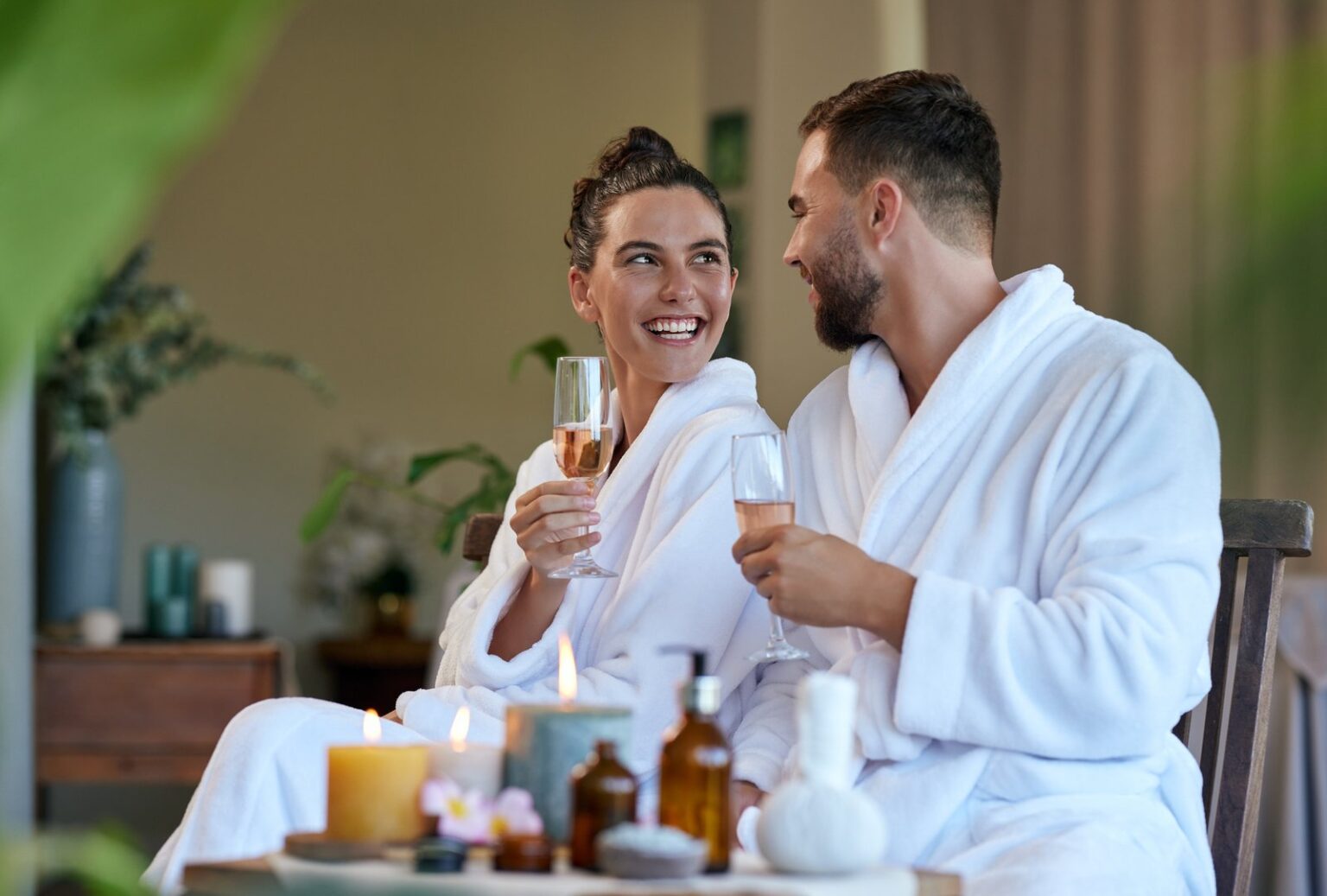 a couple in white bath robes sipping champagne